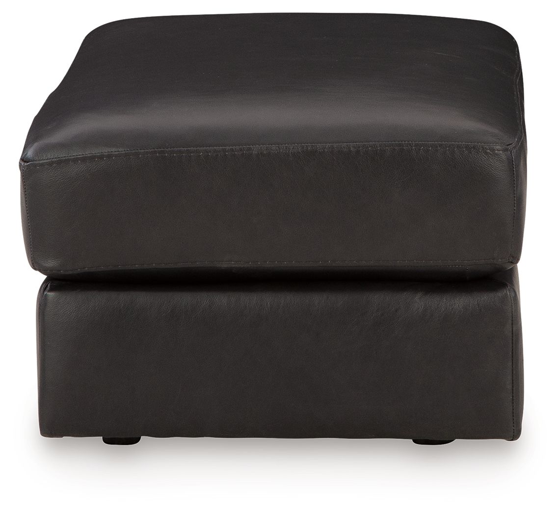 Onyx leather ottoman with rounded corners, padded top, and short legs