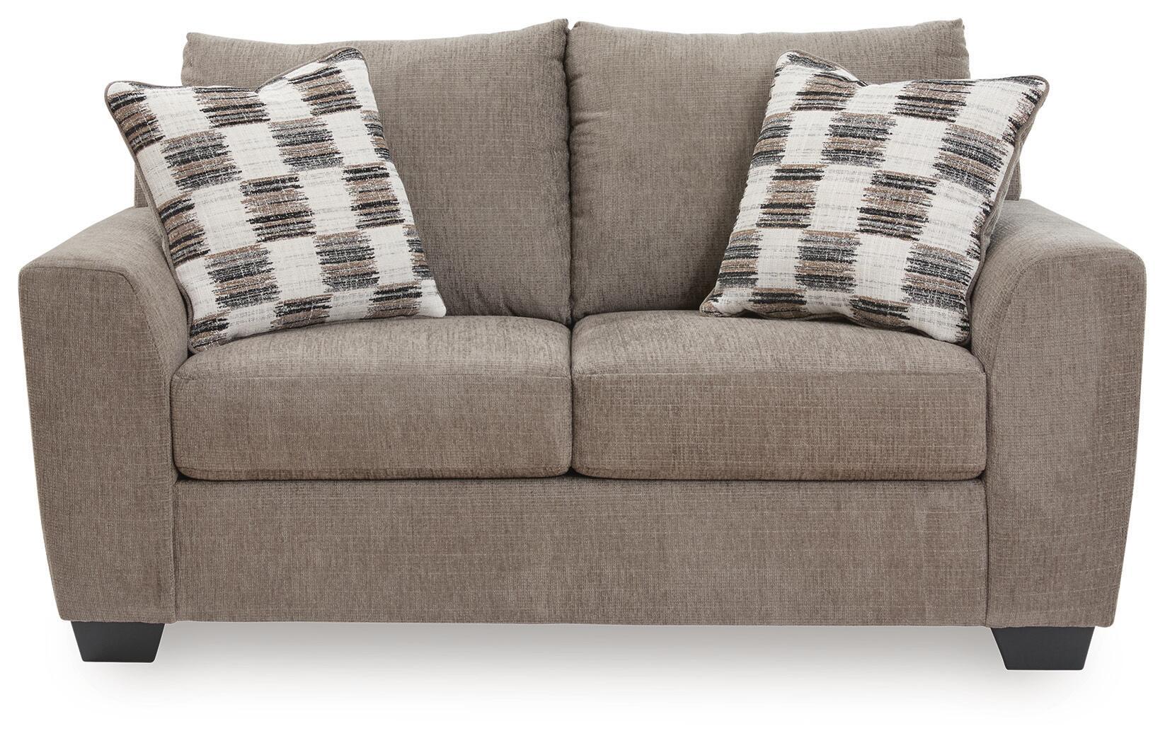Light brown loveseat with two plaid throw pillows and centered back cushion