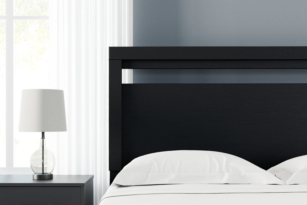 Black queen headboard above bed with white bedding
