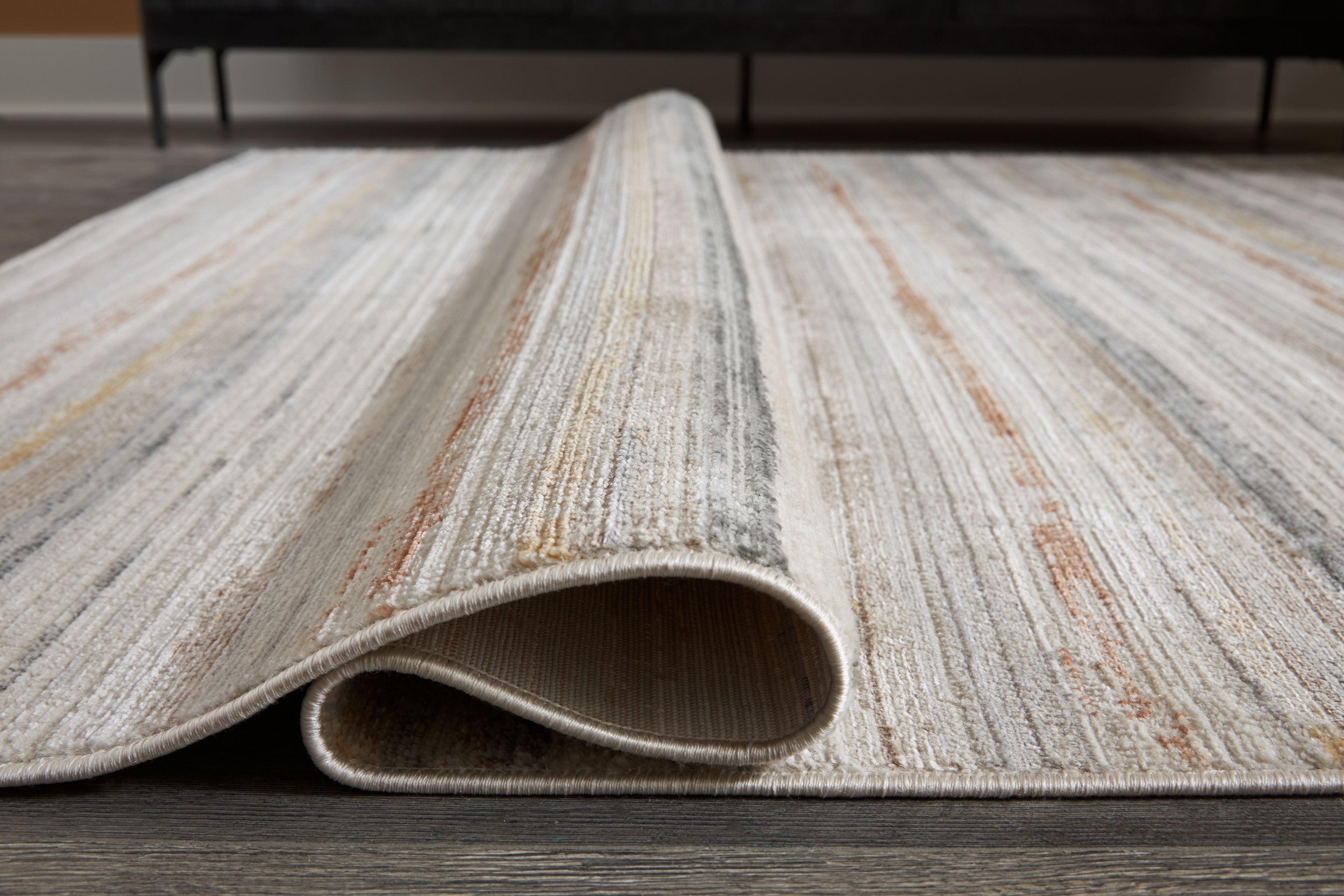 Artney rug with light brown and gray striped pattern, rolled edge view