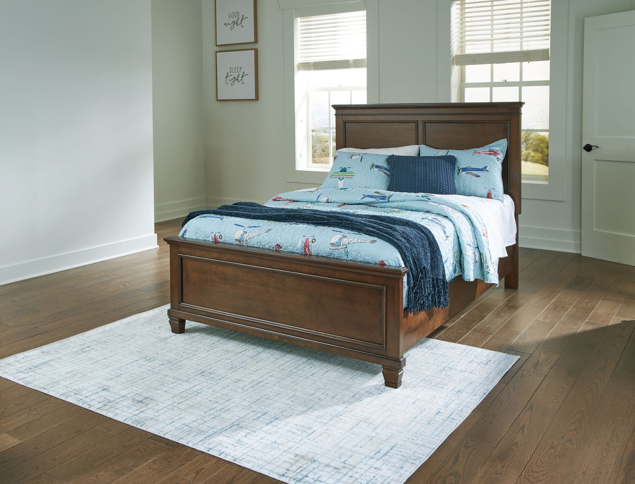 Dark brown panel bed frame with blue bedding and visible front storage drawers