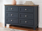 Blue dresser with six drawers, round silver knobs, and brown wood top