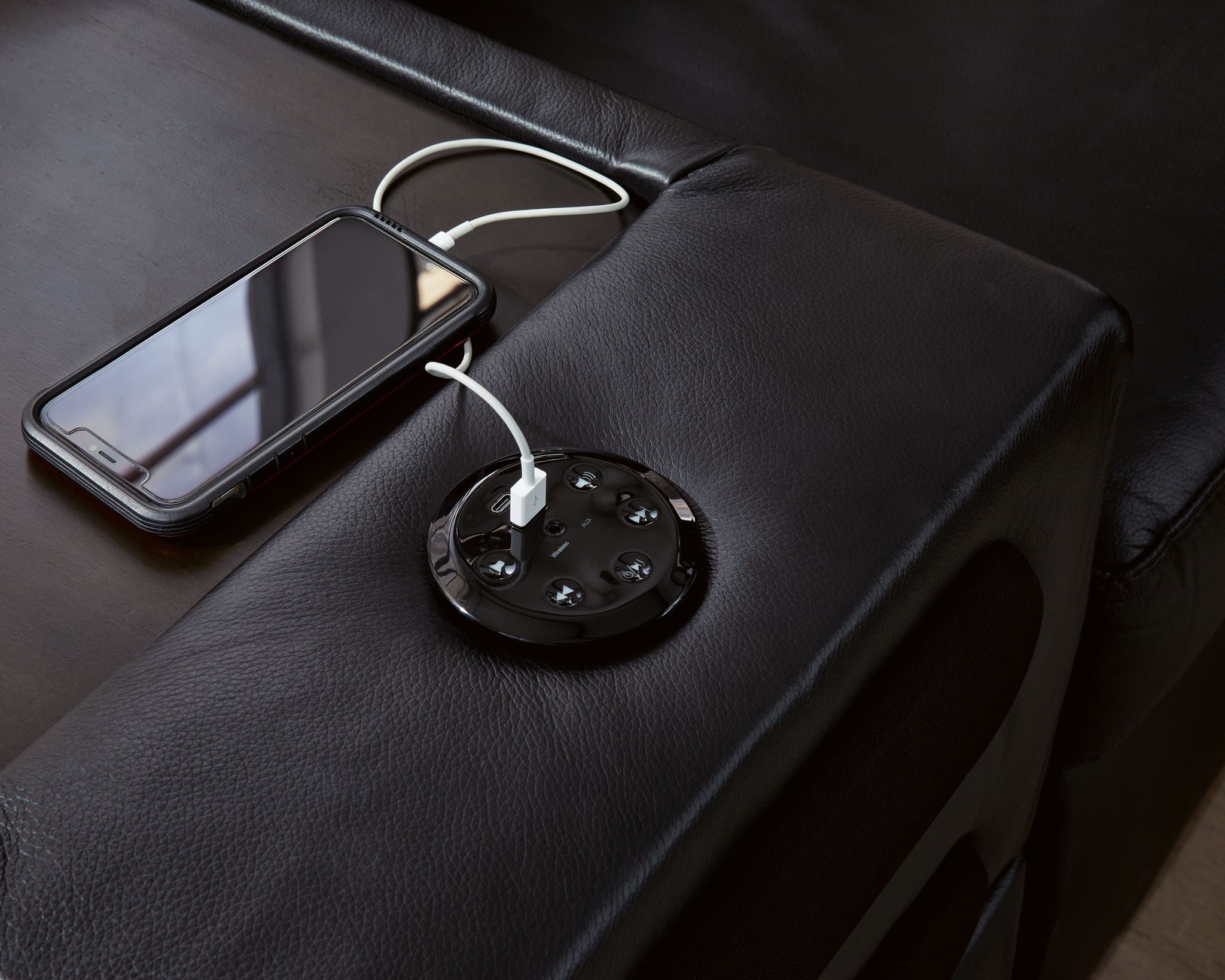 Black sectional sofa seat with built-in power outlet and charging ports