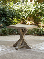 Beige square end table outdoors with wide square top and X-style pedestal legs