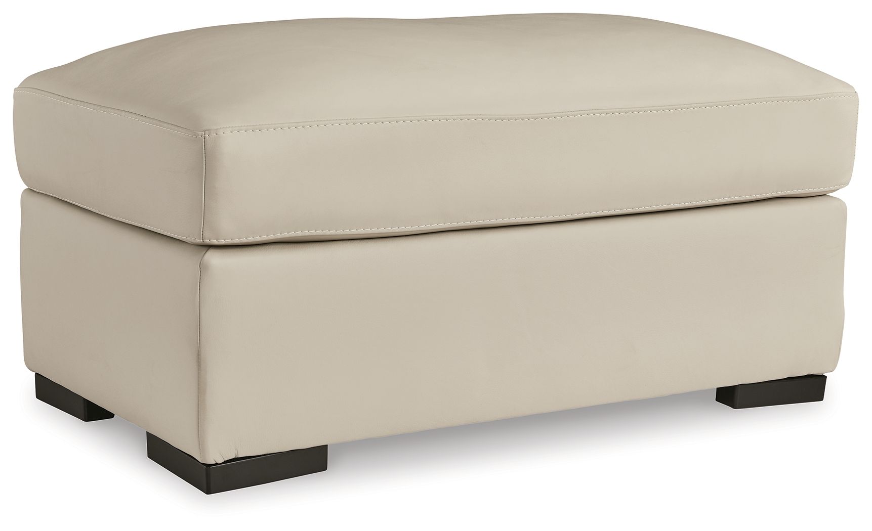 Almond upholstered ottoman with rounded top, stitched seams, and dark block feet.