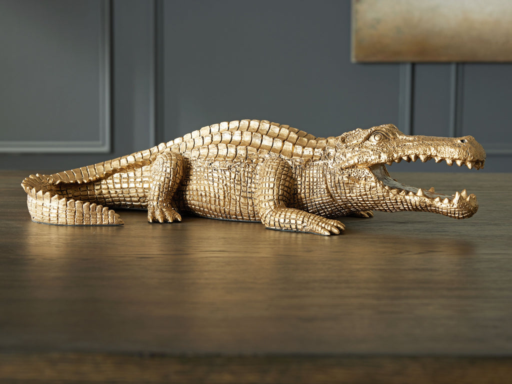 Antique gold crocodile sculpture lying on side, textured body and teeth