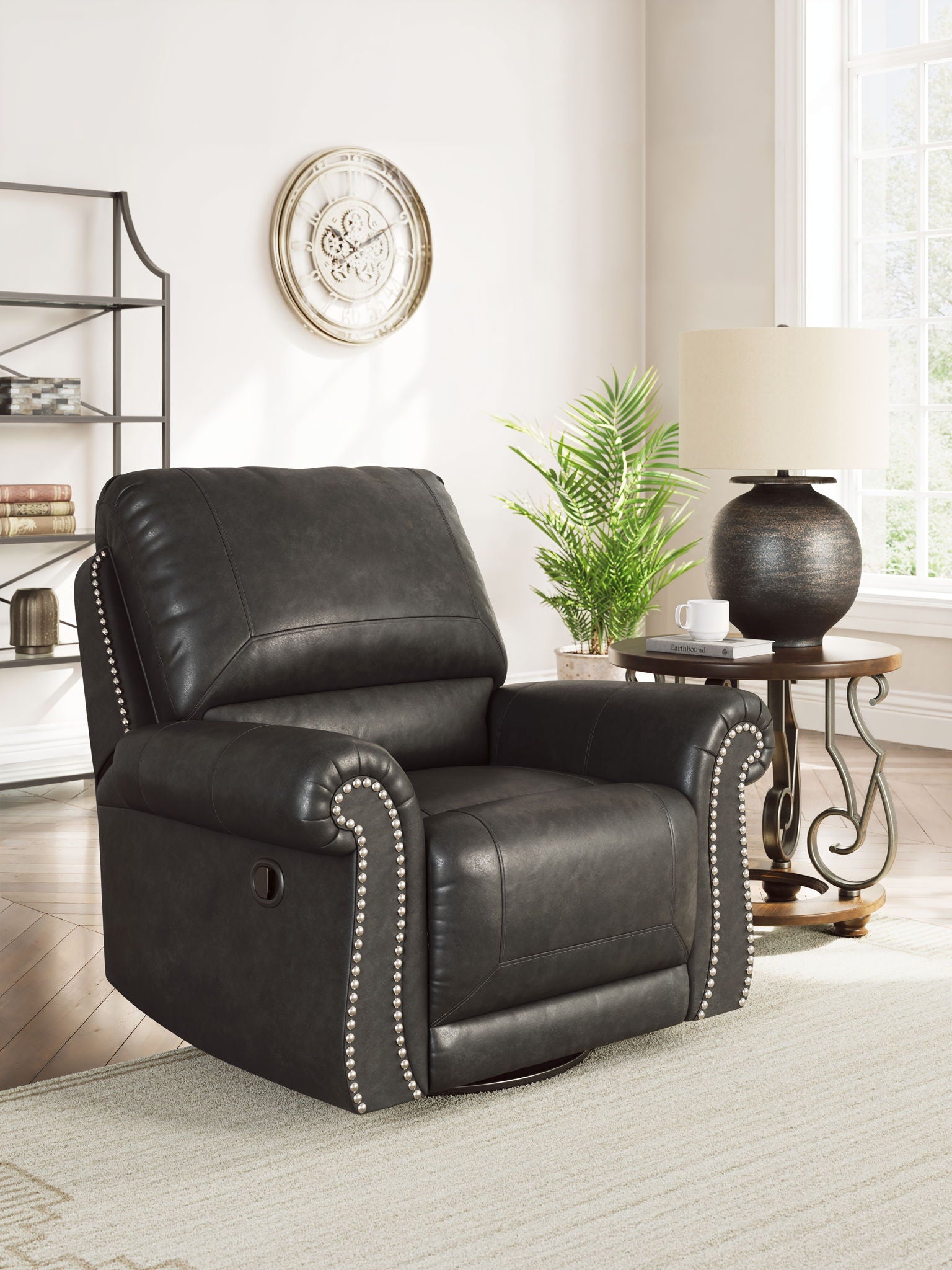 Dark gray swivel recliner with cushioned back, padded arms, and studded trim