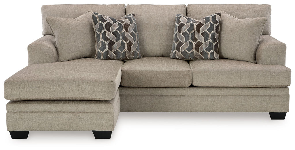 Taupe sofa chaise with three seat cushions and two geometric patterned throw pillows