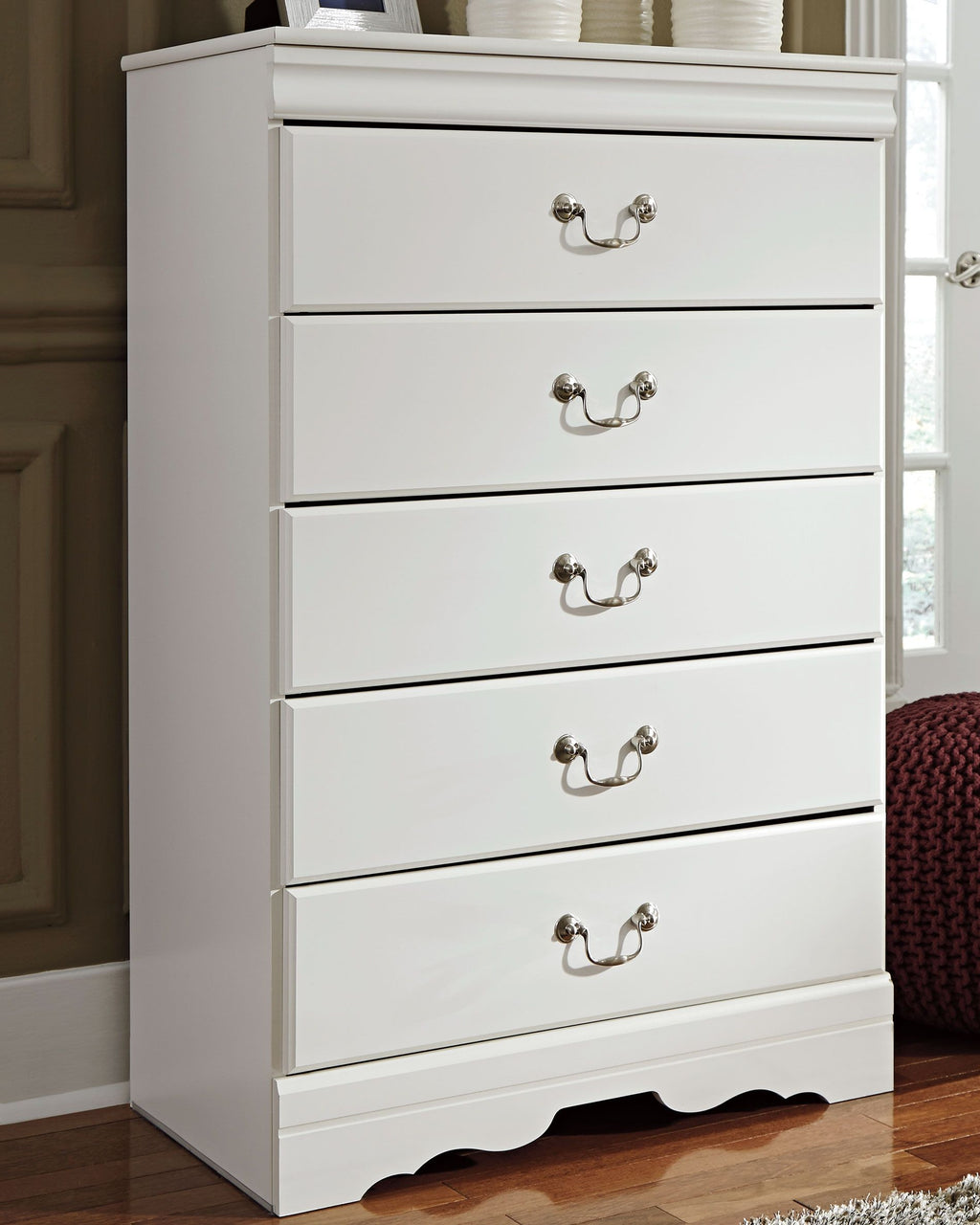 White five-drawer chest with two-knob drawer pulls and scalloped base.