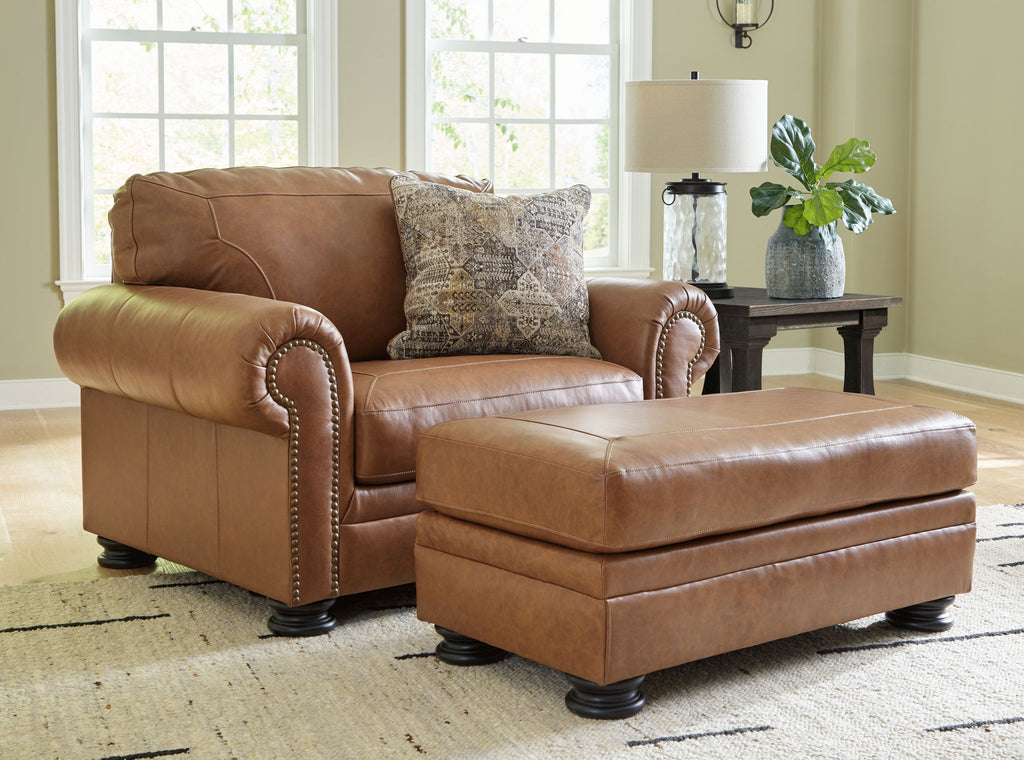 Brown armchair with patterned pillow and matching ottoman, buttoned trim details