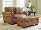 Brown armchair with patterned pillow and matching ottoman, buttoned trim details