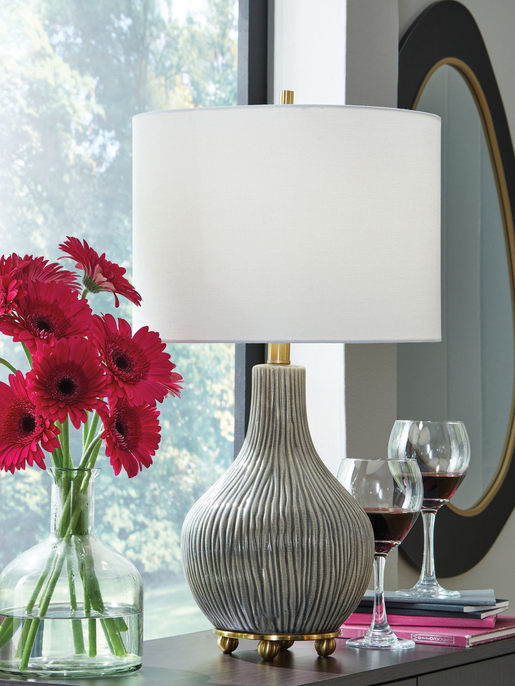 Ceramic table lamp with gray ribbed base, gold stem, and white drum shade
