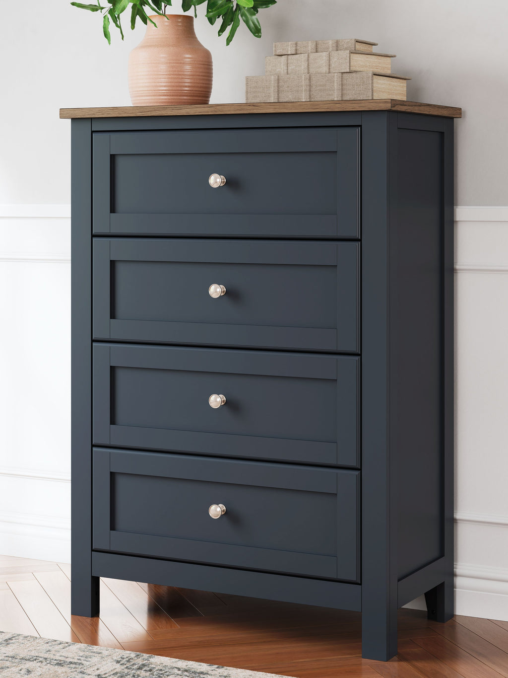Four-drawer dark blue chest with metal knobs and a light wood top.