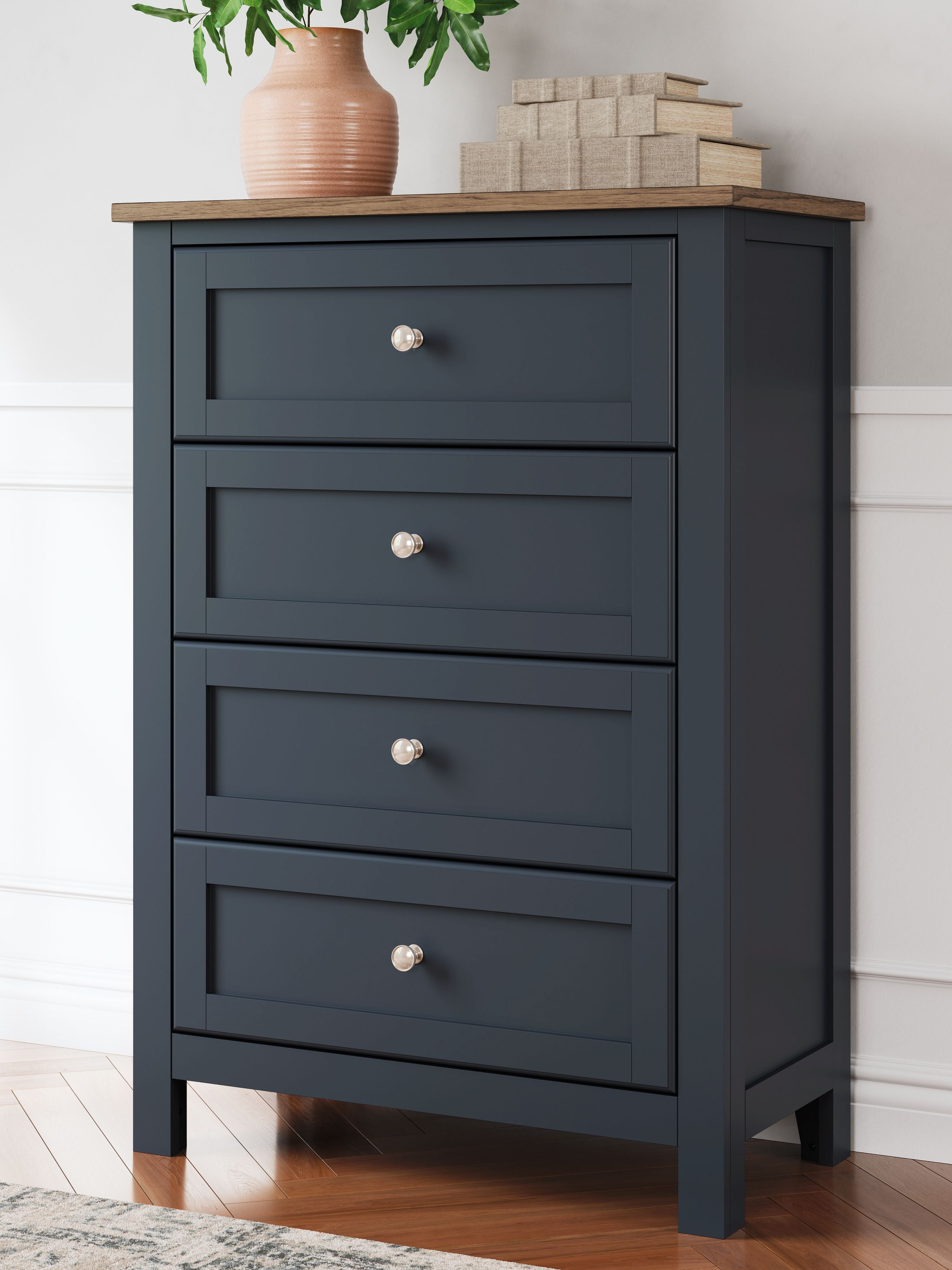 Four-drawer dark blue chest with metal knobs and a light wood top.