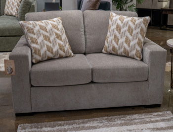 Gray upholstered loveseat with two geometric throw pillows