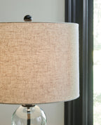 Glass table lamp with beige drum shade and clear stacked sphere base
