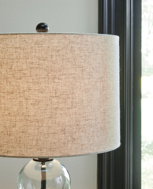 Glass table lamp with beige drum shade and clear stacked sphere base