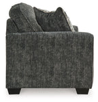 Gunmetal gray loveseat close-up with textured fabric, armrest, and patterned pillow