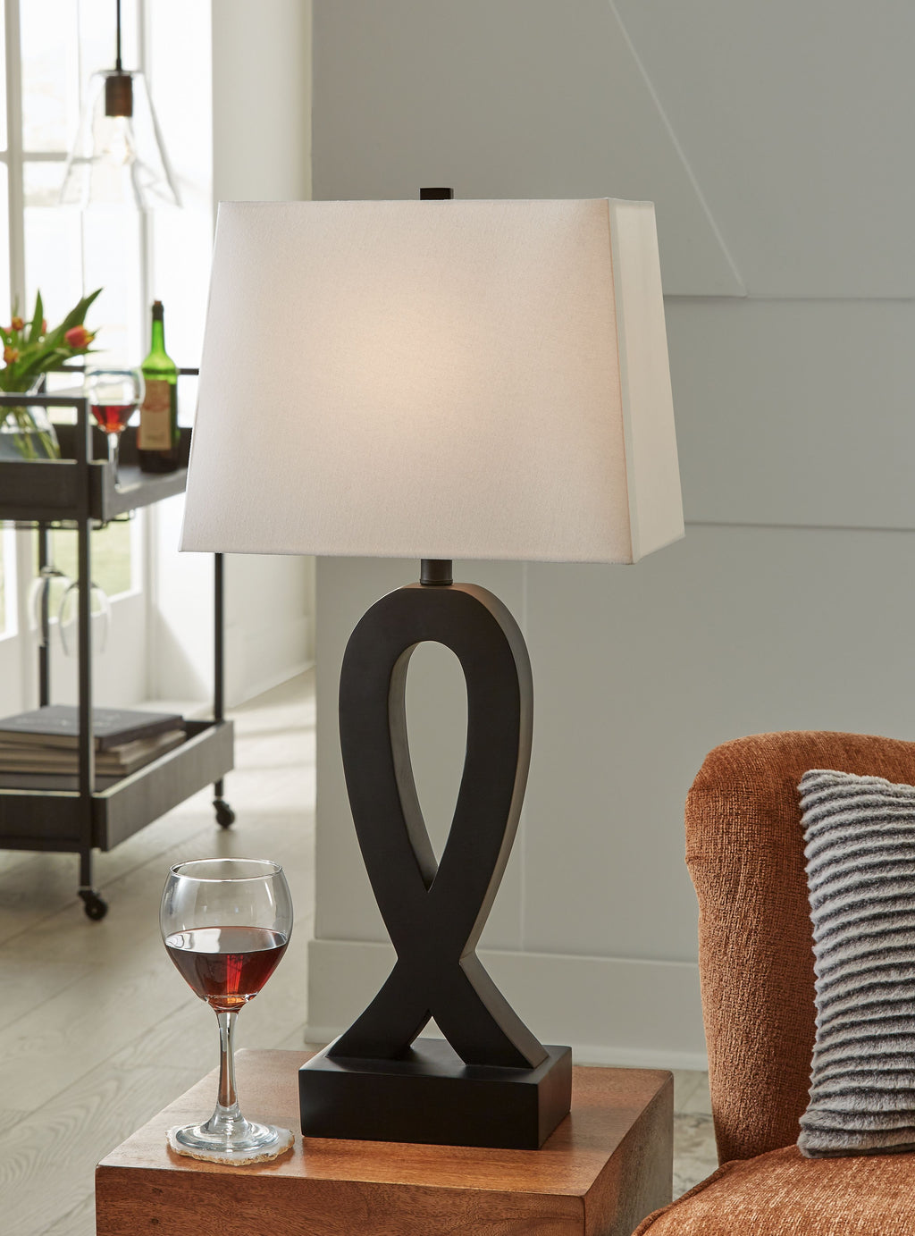 Black table lamp with white square shade and ribbon-style cutout base