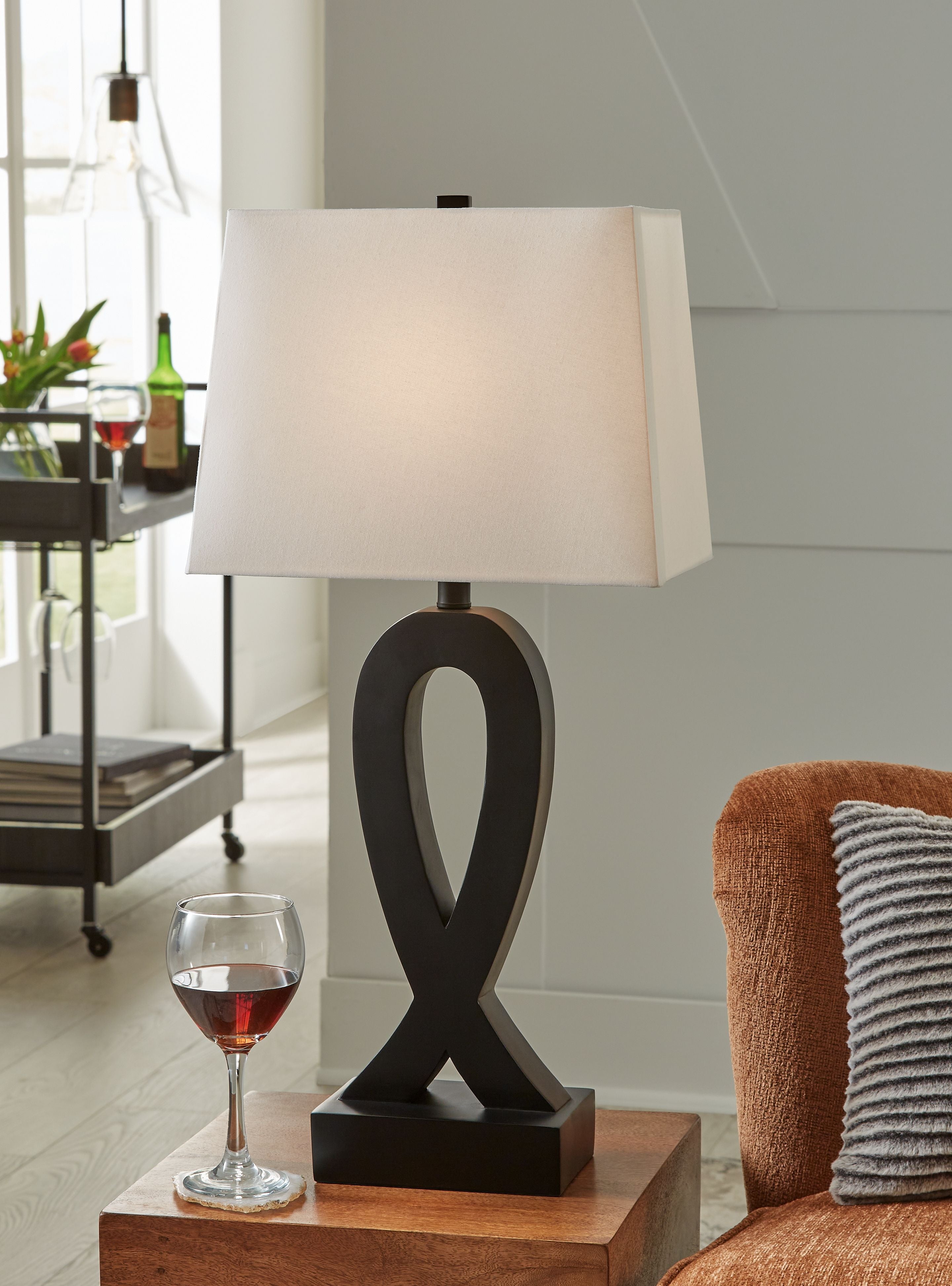Black table lamp with white square shade and ribbon-style cutout base