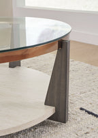 Round cocktail table corner detail with glass top, dark leg, and wood-tone rim