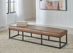 Caramel brown accent bench with tufted cushions and black metal legs