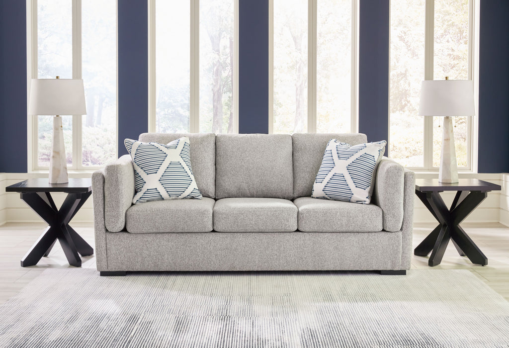Pewter fabric sofa with two patterned throw pillows and three seat cushions