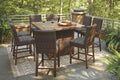 Outdoor fire pit table set with light brown woven barstools around a rectangular tabletop