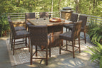 Outdoor fire pit table set with light brown woven barstools around a rectangular tabletop