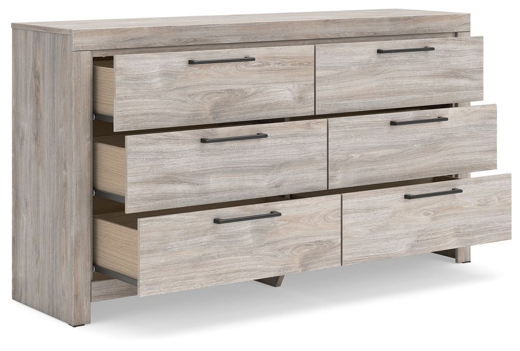 Six-drawer dresser with partially open drawers in light gray wood and dark bar pulls.