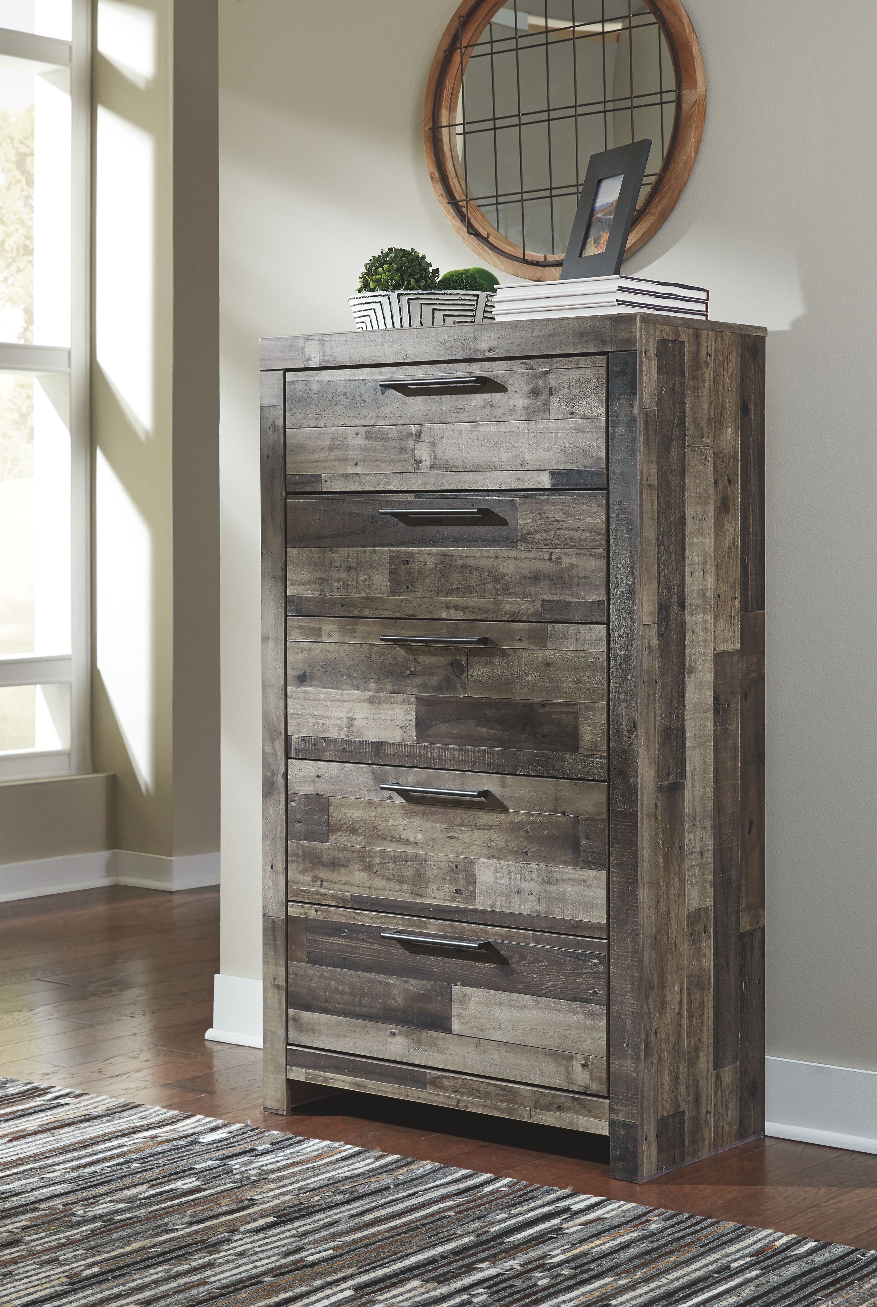 Weathered wood dresser with multiple drawers and round mirror above