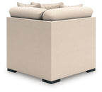Upholstered wedge chair with light beige fabric cushions and squared arms