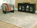 Rossbury rug, light beige with green and rust-speckled pattern, textured flat weave