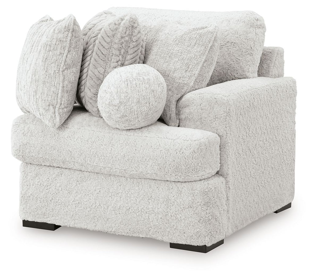 Single corner chair with textured light gray fabric, rounded arm, and bolster cushion
