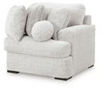 Single corner chair with textured light gray fabric, rounded arm, and bolster cushion
