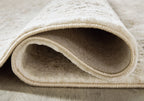 Beige rug edge with bound border, showing plush pile and folded underside