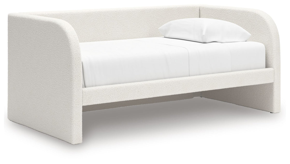 White upholstered day bed with curved arms and a folded pillow