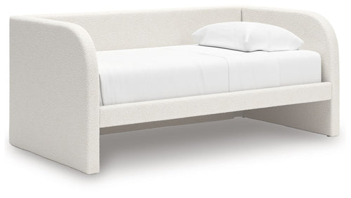 White upholstered day bed with curved arms and a folded pillow