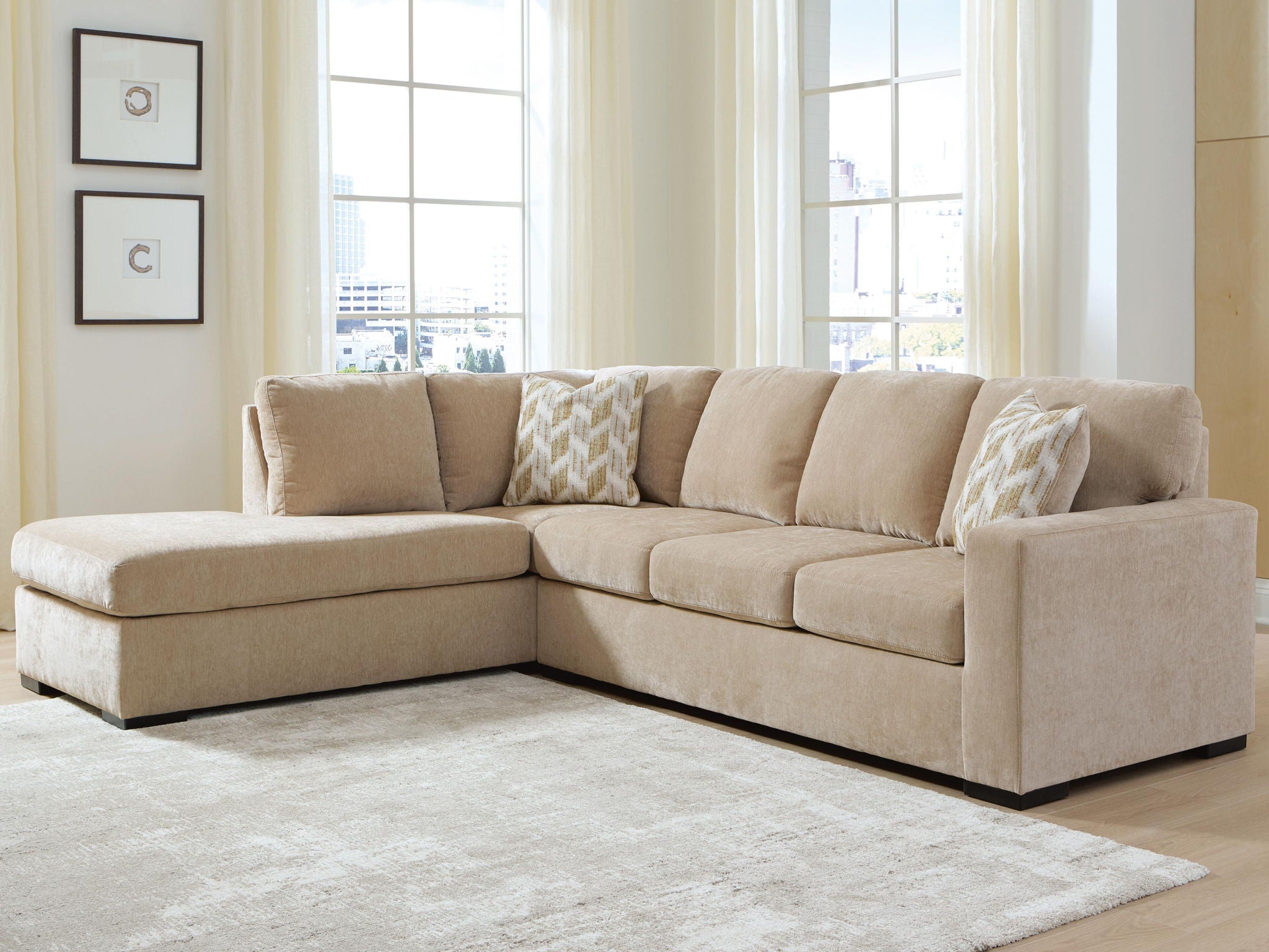 Light brown L-shaped sleeper sectional sofa with corner chaise and fabric throw pillows