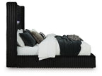 Black upholstered bed with ribbed frame, raised headboard, and stacked pillows