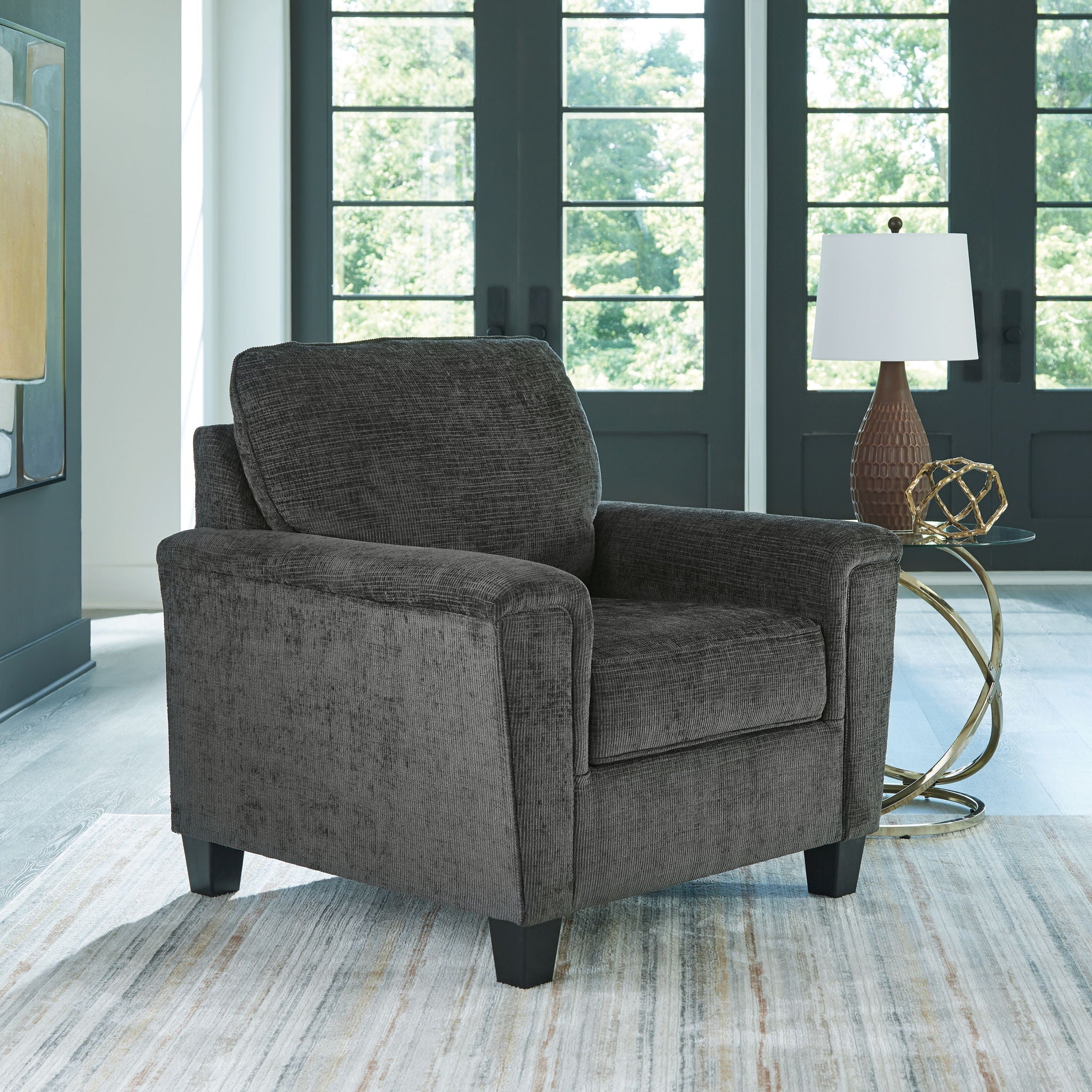 Dark gray upholstered armchair with high backrest and wide cushioned seat