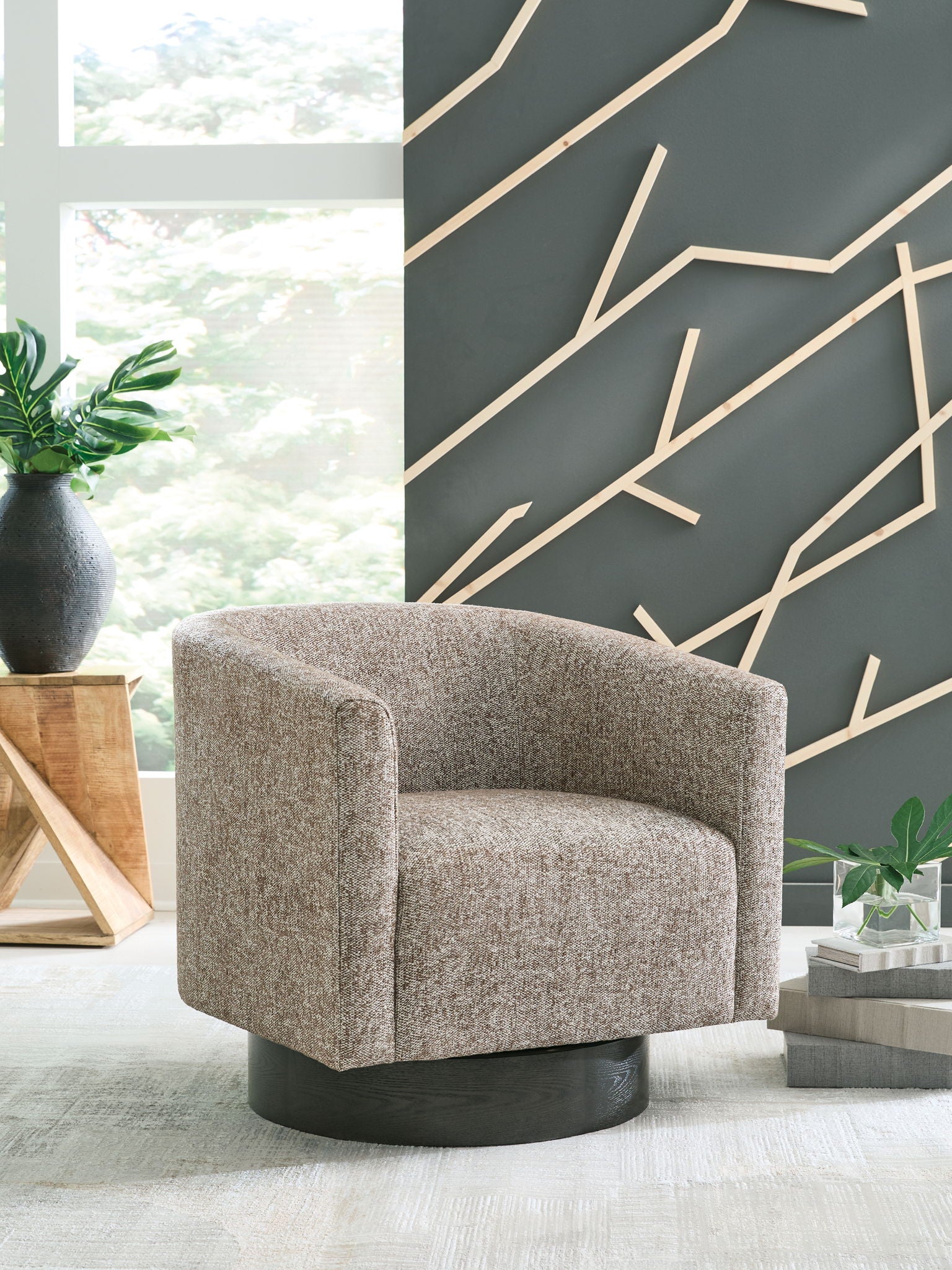 Gray swivel accent chair with rounded arms and bucket seat, black circular base