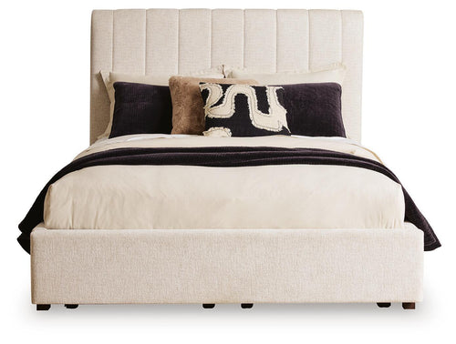 Beige queen upholstered bed with tall tufted headboard and dark accent pillows on white bedding