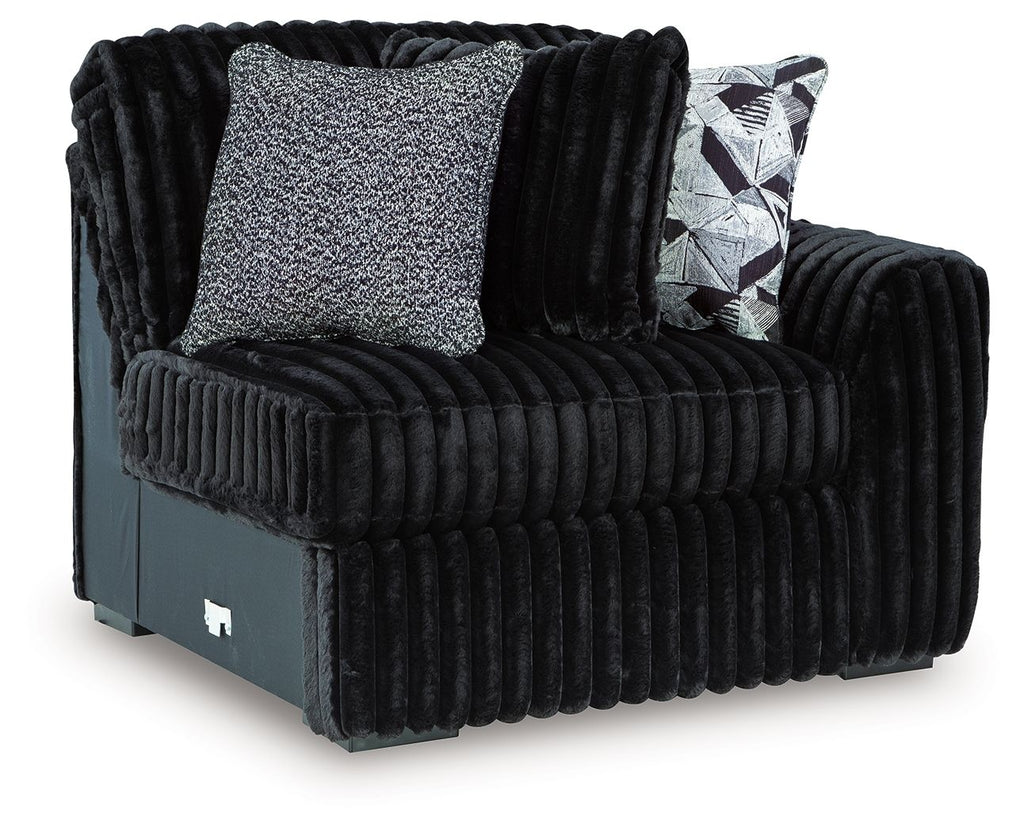 Onyx corduroy corner accent chair with two throw pillows, one patterned and one gray-textured