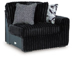 Onyx corduroy corner accent chair with two throw pillows, one patterned and one gray-textured