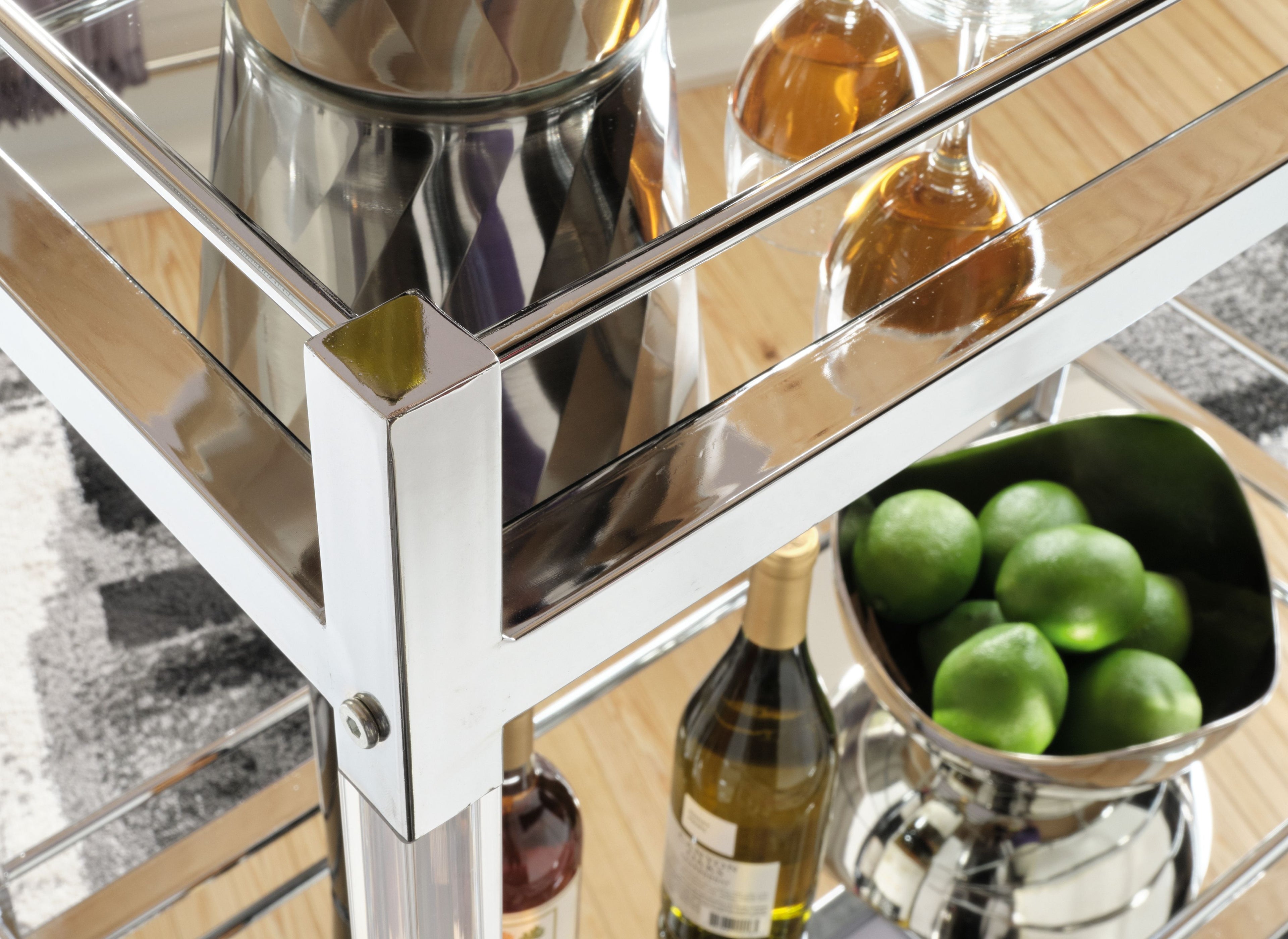 Glass shelves and reflective silver corner details on a bar cart