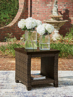 Rectangular outdoor side table with dark brown top and woven base, open lower shelf