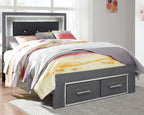 Gray bed with dark headboard and two storage drawers, colorful quilt and pillows