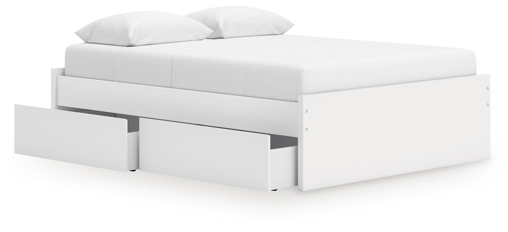 White platform bed with padded headboard and visible storage drawers