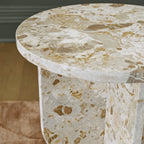 Beige stone-look accent table: close-up of round tabletop and pedestal edge
